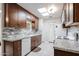 Bright kitchen featuring granite countertops, white appliances, and skylights at 14300 W Bell Rd # 100, Surprise, AZ 85374