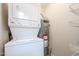Laundry room with stacked washer and dryer and water heater at 14300 W Bell Rd # 100, Surprise, AZ 85374