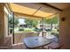 Enclosed patio with stone table and chairs overlooking a landscaped backyard at 14300 W Bell Rd # 100, Surprise, AZ 85374