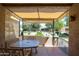 Enclosed patio with stone table and chairs overlooking a landscaped backyard at 14300 W Bell Rd # 100, Surprise, AZ 85374