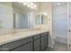 Bright bathroom with gray cabinets, white countertops, and modern lighting fixtures at 16355 W Desert Mirage Dr, Surprise, AZ 85388