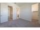 Spacious bedroom featuring carpeted floors, neutral walls, and multiple doorways at 16355 W Desert Mirage Dr, Surprise, AZ 85388