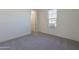 A clean and bright bedroom with carpeted floors, neutral walls, and a window for natural light at 16355 W Desert Mirage Dr, Surprise, AZ 85388