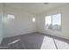 A bright bedroom has carpeted floors, three windows and a neutral color palette at 16355 W Desert Mirage Dr, Surprise, AZ 85388