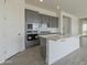 Modern kitchen featuring gray cabinets, white quartz countertops, and stainless steel appliances at 16355 W Desert Mirage Dr, Surprise, AZ 85388