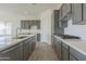 Modern kitchen featuring gray cabinets, white quartz countertops, and stainless steel appliances at 16355 W Desert Mirage Dr, Surprise, AZ 85388