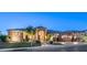 Impressive home exterior showcasing a stone facade, tile roof, and manicured landscaping at dusk at 16432 S Mountain Stone Trl, Phoenix, AZ 85048