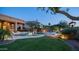 Beautiful backyard featuring a sparkling pool, patio area, lush lawn, and mature landscaping at 16432 S Mountain Stone Trl, Phoenix, AZ 85048