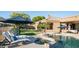 Inviting backyard oasis with a sparkling pool, sun loungers, and lush greenery at 16432 S Mountain Stone Trl, Phoenix, AZ 85048