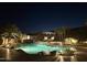 Night view of a luxurious pool with rock features, lounge chairs, and lush landscaping at 16432 S Mountain Stone Trl, Phoenix, AZ 85048