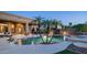 Backyard oasis showcasing a pool, spa, covered patio, and landscaped surroundings with palm trees at 16432 S Mountain Stone Trl, Phoenix, AZ 85048