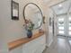 Entryway features a modern accent cabinet, decorative mirror, and a view into the house at 18746 W Rancho Dr, Litchfield Park, AZ 85340
