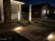 Landscaped front yard featuring ambient lighting illuminating cacti and stone pathway at dusk at 18746 W Rancho Dr, Litchfield Park, AZ 85340