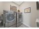 Efficient laundry room showcasing sleek, side-by-side, front-load washer and dryer units at 18746 W Rancho Dr, Litchfield Park, AZ 85340