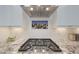 Gas cooktop over granite countertops featuring white tile backsplash and modern vent hood at 18746 W Rancho Dr, Litchfield Park, AZ 85340