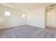 A spacious bedroom with carpet flooring and plenty of natural light from two windows at 18938 W Ocotillo Rd, Waddell, AZ 85355