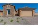 Charming home exterior featuring stone accents, a two-car garage, and low-maintenance desert landscaping at 18938 W Ocotillo Rd, Waddell, AZ 85355