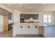 Modern kitchen with grey cabinets, stainless steel appliances, and a white island with ample counter space at 18938 W Ocotillo Rd, Waddell, AZ 85355