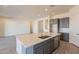A spacious kitchen with a large island, gray cabinets, and stainless steel appliances at 18938 W Ocotillo Rd, Waddell, AZ 85355