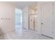Bathroom boasts neutral tile flooring and a glass shower with a white door at 18950 W Ocotillo Rd, Waddell, AZ 85355