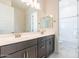 Bathroom featuring double sinks, a mirror, and a bright open shower at 18950 W Ocotillo Rd, Waddell, AZ 85355