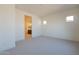 Bright bedroom with neutral walls, plush carpeting, and an open ensuite bathroom at 18950 W Ocotillo Rd, Waddell, AZ 85355