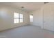 Bright, carpeted bedroom features two windows and fresh neutral paint at 18950 W Ocotillo Rd, Waddell, AZ 85355