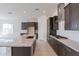 Gourmet kitchen with dark cabinetry, stainless steel appliances, and a center island at 18950 W Ocotillo Rd, Waddell, AZ 85355