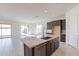Open kitchen featuring a granite island with a sink and modern appliances at 18950 W Ocotillo Rd, Waddell, AZ 85355