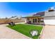 Expansive backyard with artificial turf, gravel landscaping, and a covered patio dining area at 19413 N 8Th St, Phoenix, AZ 85024