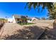 Wide backyard featuring a gravel area, artificial turf, covered patio, and solar panels on the roof at 19413 N 8Th St, Phoenix, AZ 85024