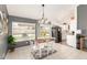 Bright dining area features a wood table, white chairs, and views of the backyard through a large window at 19413 N 8Th St, Phoenix, AZ 85024