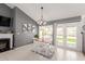 Charming dining area featuring a fireplace, backyard view, and a modern chandelier at 19413 N 8Th St, Phoenix, AZ 85024