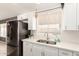 Cozy kitchen with white shaker cabinets, quartz countertops, stainless steel appliances, and a double-bowl sink at 19413 N 8Th St, Phoenix, AZ 85024