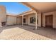 Spacious covered back patio with brick flooring, fireplace, and elegant wooden door at 20139 E Via Del Oro --, Queen Creek, AZ 85142