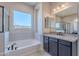 This bathroom features a soaking tub, walk in shower, and vanity with a granite countertop at 20234 W Catalina Dr, Buckeye, AZ 85396