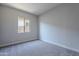 This bedroom offers a light gray color palette, a window and neutral carpet flooring at 20234 W Catalina Dr, Buckeye, AZ 85396