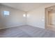 This bedroom features neutral colored carpet, a door, and dual windows at 20234 W Catalina Dr, Buckeye, AZ 85396