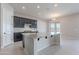 Modern kitchen with dark cabinets, granite countertops, stainless steel appliances, and tile flooring at 20234 W Catalina Dr, Buckeye, AZ 85396