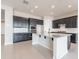 Spacious kitchen features dark cabinetry, granite countertops, stainless appliances and a large island at 20234 W Catalina Dr, Buckeye, AZ 85396