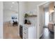 Bar area with wine fridge, marble countertop, and open access to a living room and bathroom at 21663 N 57Th Ave, Glendale, AZ 85308