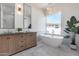 Spa-like bathroom with double vanity, freestanding tub, and large window at 21663 N 57Th Ave, Glendale, AZ 85308