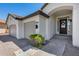 Close-up of a home's front door, three-car garage, and manicured landscaping at 21663 N 57Th Ave, Glendale, AZ 85308