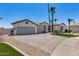Home featuring a three-car garage, mature palm trees, and a well-maintained lawn at 21663 N 57Th Ave, Glendale, AZ 85308