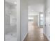 Open-concept design with hardwood floors leads to a luxurious glass-enclosed shower at 21663 N 57Th Ave, Glendale, AZ 85308