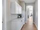 Hallway featuring white built-in cabinets, marble countertops, and hardwood flooring for a clean, contemporary look at 21663 N 57Th Ave, Glendale, AZ 85308