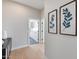 Bright hallway featuring light wood floors, gray walls, and stylish botanical art at 21663 N 57Th Ave, Glendale, AZ 85308