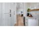Hallway features white cabinetry with bronze hardware, a counter with modern appliances, and neutral decor at 21663 N 57Th Ave, Glendale, AZ 85308