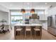 Bright kitchen featuring an island with barstools, stainless steel appliances, and a view of the water at 21663 N 57Th Ave, Glendale, AZ 85308