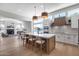 Modern kitchen with white cabinets, island with seating, and large windows overlooking the water at 21663 N 57Th Ave, Glendale, AZ 85308